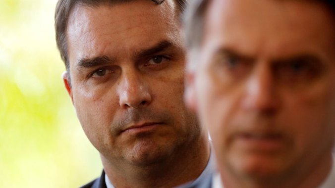 FILE PHOTO: Flavio Bolsonaro, son of Brazil's President Jair Bolsonaro is seen behind him at the transition government building in Brasilia