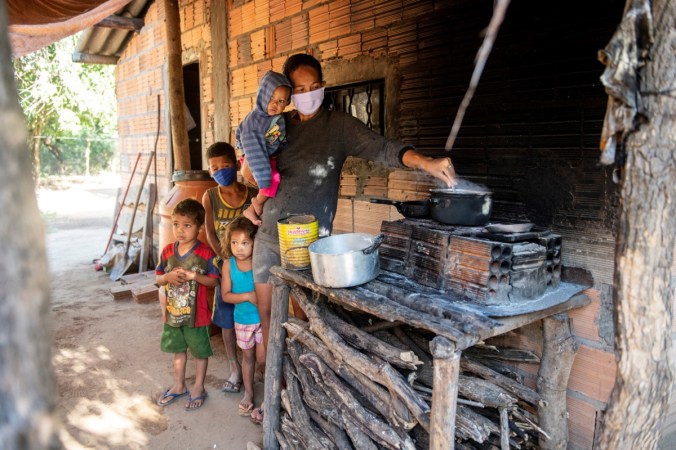 Mutter mit Schutzmaske und Kindern am Herd