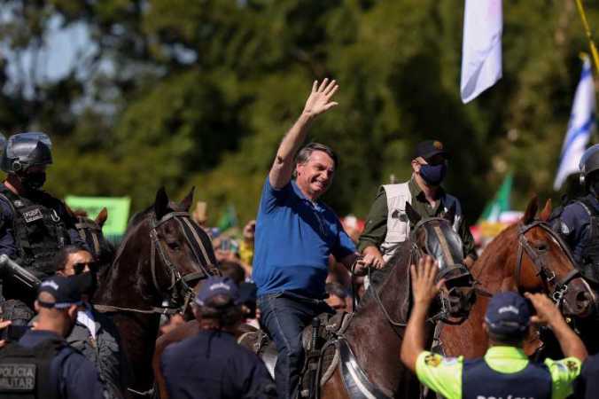 O presidente Jair Bolsonaro cumprimenta apoiadores na frente do Palácio do Planalto